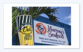 Logo for Macray's Seafood with a Del's Lemonade in the foreground